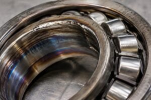Close-up inspection of a failed spherical roller bearing showing inner ring creep and heat discoloration